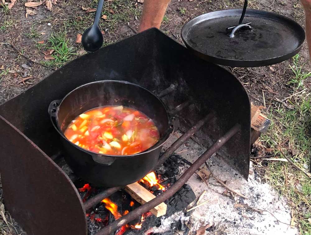 stiring the camp oven vegetable stew